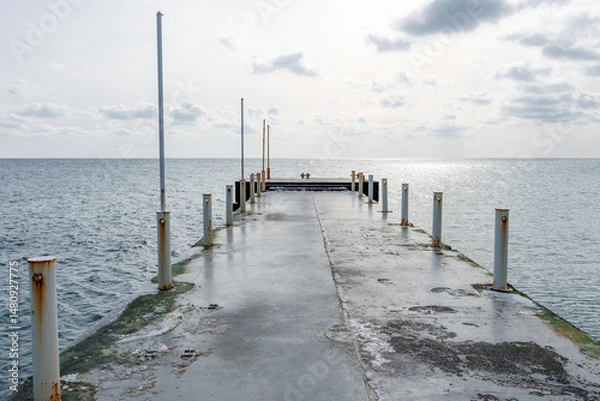 Fototapeta Empty concrete pier by the winter sea on a sunny day