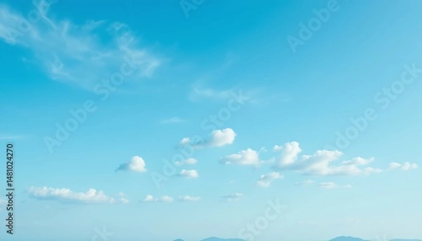 Fototapeta Serene blue sky with clouds and distant mountains.