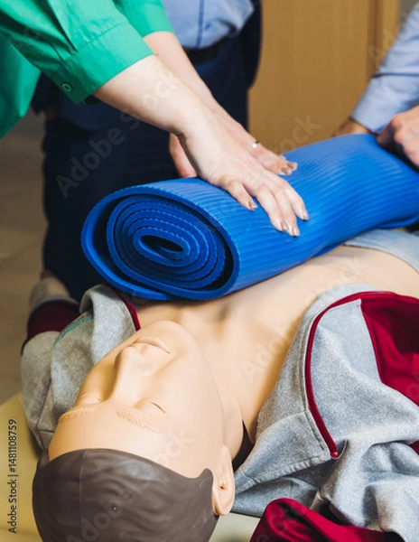 Fototapeta First aid training course with dummy, CPR emergency reanimation procedure on mannequin, instructor demonstrating medical training with doll, chest compression and applying bandage and tourniquet
