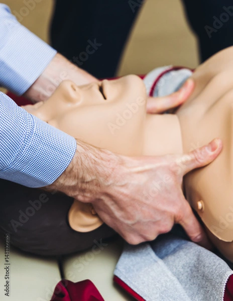 Fototapeta First aid training course with dummy, CPR emergency reanimation procedure on mannequin, instructor demonstrating medical training with doll, chest compression and applying bandage and tourniquet