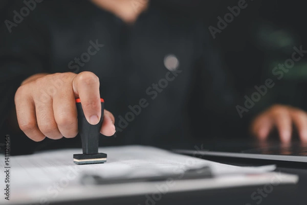 Fototapeta Businessman validates and manages business documents and agreements, approval stamp, signing a business contract approval of contract documents confirmation or warranty certificate,