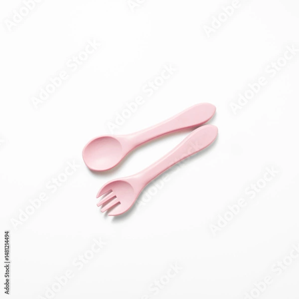 Obraz Baby feeding spoon and fork in soft pink. Ideal for baby gear, infant nutrition content, or early childhood care themes.