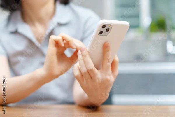 Fototapeta 室内でスマートフォンを操作する女性