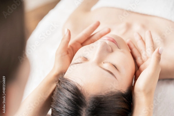 Obraz エステサロンで顔をマッサージされる若い女性