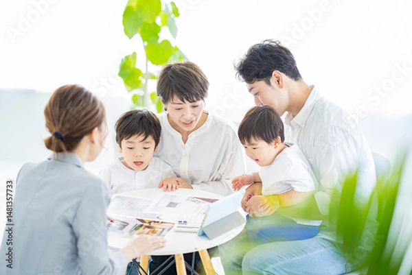 Obraz スーツ姿の女性からインテリアの説明を受ける家族