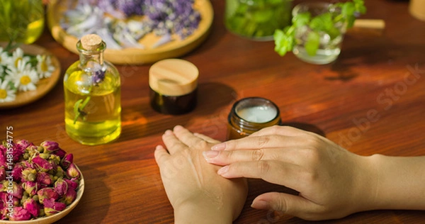 Fototapeta Hands are applying white moisturizing cream, a cream specifically for hands to make the skin smooth and bright. The cosmetic product has natural herbal ingredients, safe to use. Herbal cosmetics.