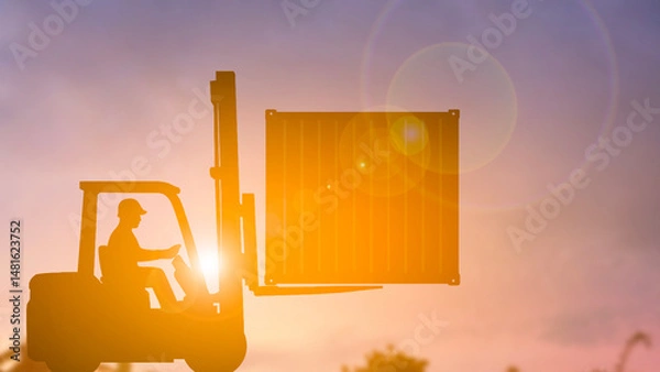 Fototapeta Silhouette of forklift lifting container box blur background