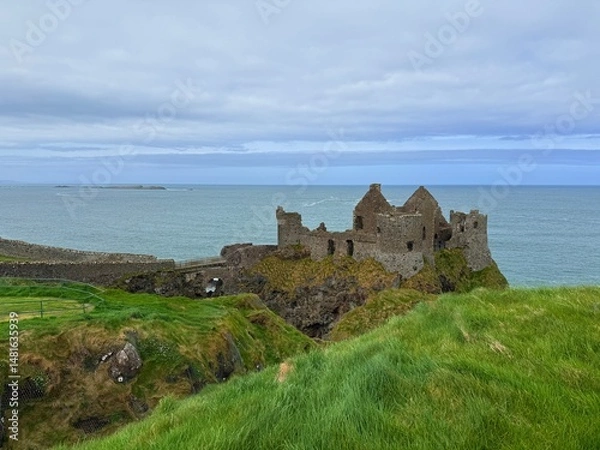 Obraz Dunluce Castle, perched on Northern Ireland's rugged Antrim Coast, showcases dramatic medieval ruins against windswept cliffs. Its weathered stone walls and sea views evoke history and mystery, ideal 