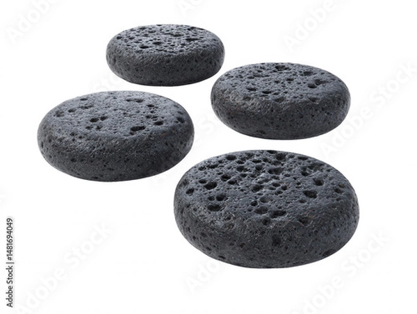 Fototapeta Four dark gray porous volcanic lava stones are artfully arranged on a pure white background creating a simple yet elegant natural design to inspire wellness.