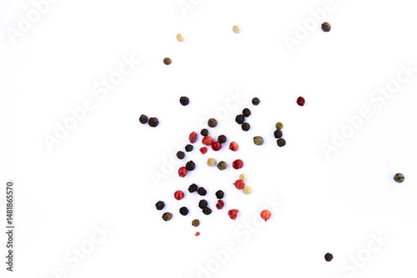 Fototapeta Close-up of peppercorns - red, green, black and white, scattered chaotically on a white background, aromatic spice, macro photography.