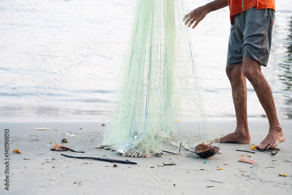 Obraz Fisherman with traditional fishing net on the beach of Kochi, India,  industry at the arabian sea coast