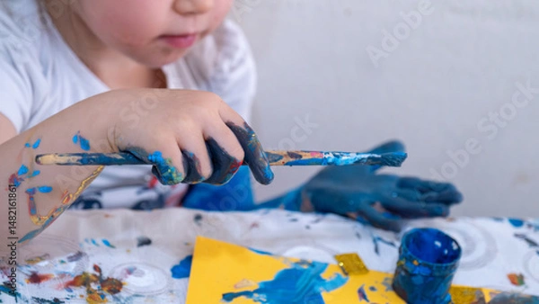 Fototapeta Happy Little Girl Engaged in Creative Finger Painting and Arts and Crafts Activities, Exploring Colors, Textures, and Shapes for Early Childhood Education, Fun Learning