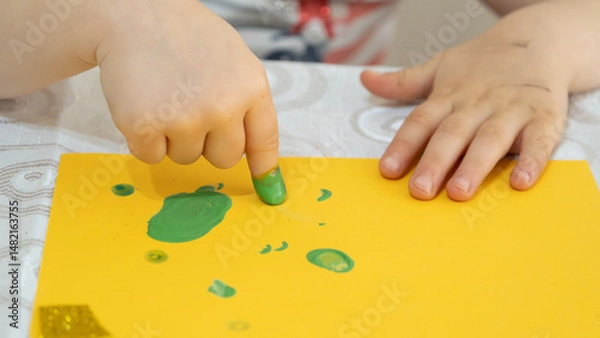 Fototapeta Colorful Finger Painting Activity for Kids with Bright Yellow Paint and Creative Learning Environment on White Background, Early Childhood Education Concept