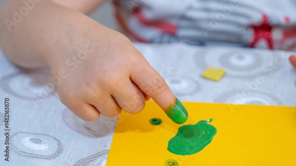Fototapeta Colorful Finger Painting Activity for Kids with Bright Yellow Paint and Creative Learning Environment on White Background, Early Childhood Education Concept