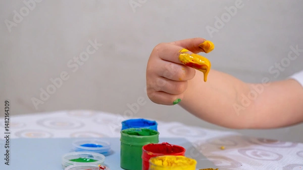 Fototapeta Colorful Finger Painting Activity for Kids with Bright Yellow Paint and Creative Learning Environment on White Background, Early Childhood Education Concept