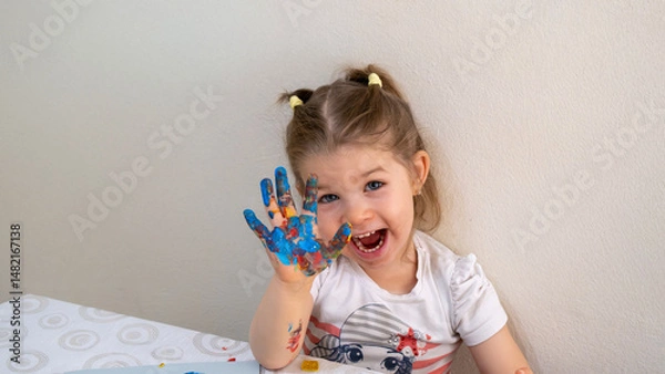 Fototapeta Joyful Child Displaying Painted Hand with Bright Colors While Smiling Happily, Promoting Early Education Through Creative Art Activities and Fun Sensory Play for Kids
