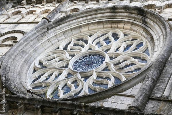 Obraz A large stone gothic church building in Cognac France with a large stained glass window