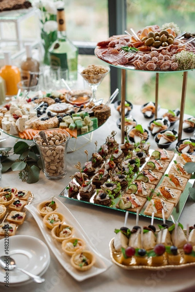Fototapeta Wedding day. Buffet table with various types of snacks and sweets in the celebration hall