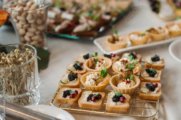 Fototapeta Wedding day. Buffet table with various types of snacks and sweets in the celebration hall