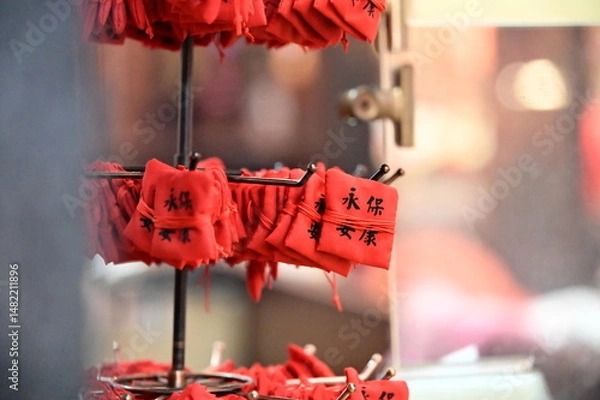 Fototapeta TWN-Mar 02, 2025: A red amulet marked with “Eternal Peace” sits neatly on a shelf inside a Taiwanese temple. Symbolizing protection and harmony, it reflects cultural traditions and spiritual beliefs.