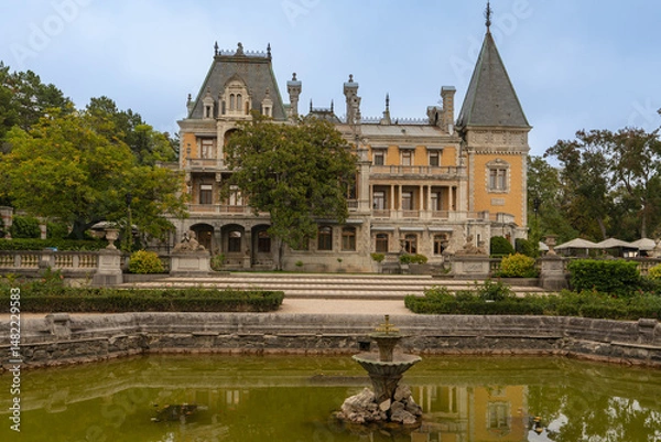 Fototapeta Massandra Palace of Emperor Alexander III. Historic mansion with intricate architecture stands behind a serene pond, reflecting its majestic facade. Yalta, Crimea - September 30, 2019