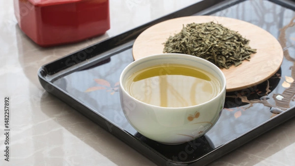 Fototapeta a glass of green tea in the foreground. tea leaf green loose on a plate in the background