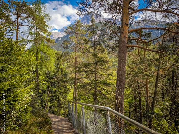 Fototapeta Breathtaking View From Leutasch Gorge Hiking Trail: Elevated Pathway With Metal Railings Winding Through Dense Alpine Forest Offering Stunning Vistas Of Rugged Karwendel Peaks In Tyrol, Austria