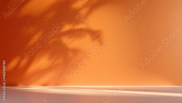 Fototapeta Palm leaf shadows cast on a bright orange wall, creating a warm and minimalistic summer vibe.