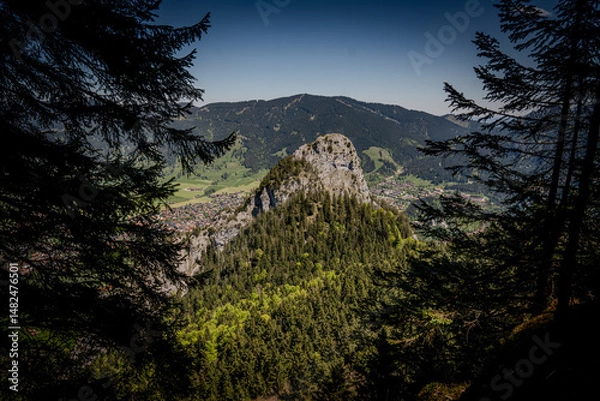Fototapeta Majestic Kofel Mountain In Oberammergau: Towering Rocky Peak Surrounded By Dense Alpine Forests And Overlooking The Picturesque Bavarian Village In The Heart Of The Lush Bavarian Alps