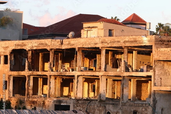 Fototapeta Ruins of old houses in the center of a big city