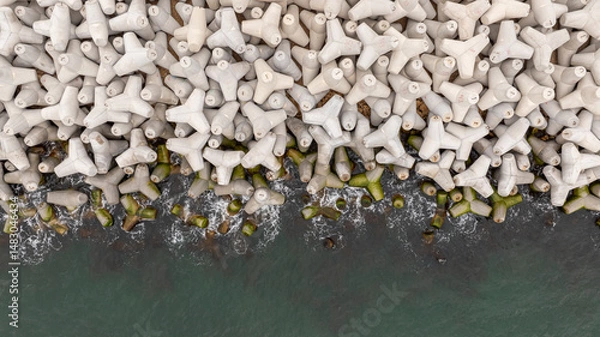 Fototapeta Aerial view of concrete tetrapod. Concrete tetrapods line.  Coastal protection. Wave breakers