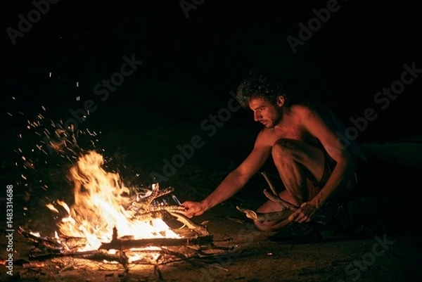 Fototapeta Camp fire flames, man adding wood