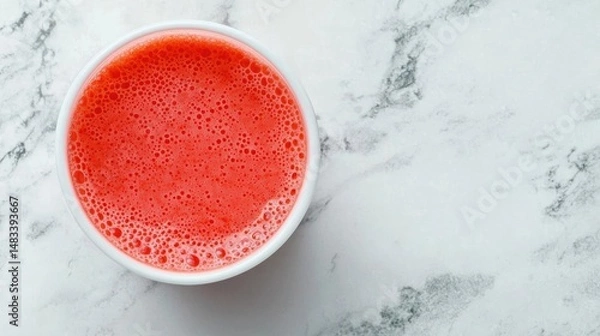 Fototapeta Top view of a small white bowl filled with a red-colored smoothie. the smoothie appears to be freshly made and has a smooth texture.