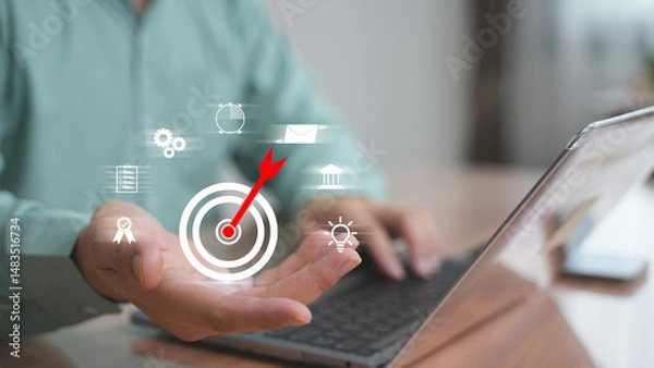 Obraz Businessman aiming digital target icon on laptop, Concept of setting goals, strategic direction, and performance target.
