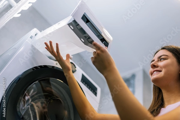 Fototapeta Girl Removing Water Container from Dryer Machine