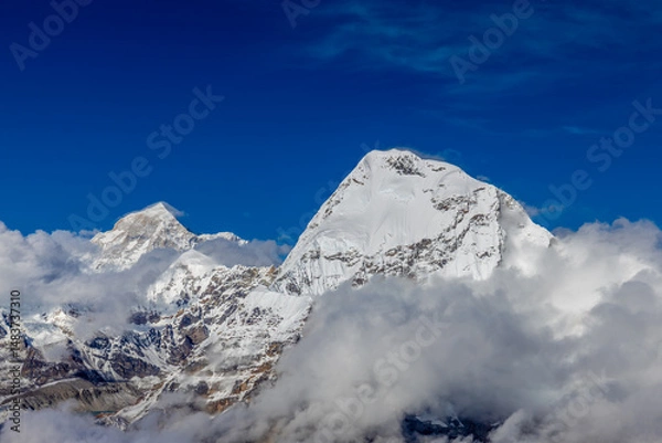 Fototapeta Mera Peak high altitude mountain summit ascent in Himalayas. Stunning views above the clouds at sunrise from the top of the mountain. Alpine route climbing on the snow path in Himalayas