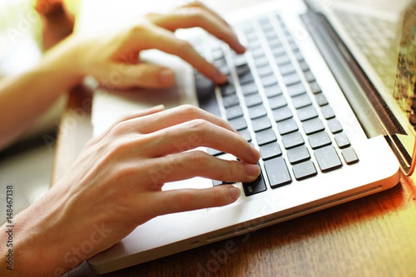 Fototapeta Hands typing on laptop computer. soft focus on keyboard.
