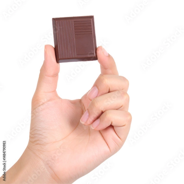 Fototapeta Hand holding a square object against a black background showcasing texture and shape with clear lighting for commercial or editorial use