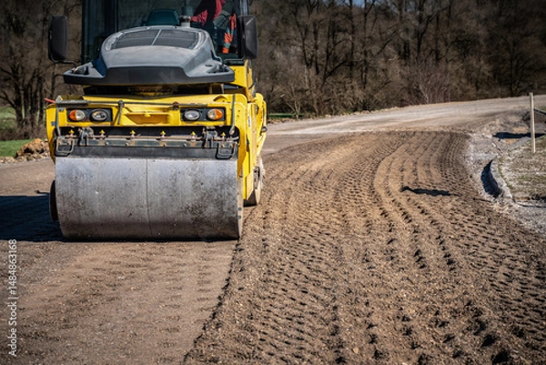 Fototapeta Generated ImageLow Angle Shot of Compact Roller on Road Construction Site Surrounded by Trees and Clear Blue Sky on Sunny Day

