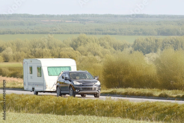 Fototapeta SUV pulling a caravan in nature