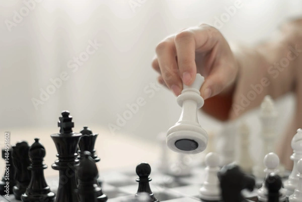 Obraz hand of businessmen moving chess in competition shows leadership, followers and business success strategies