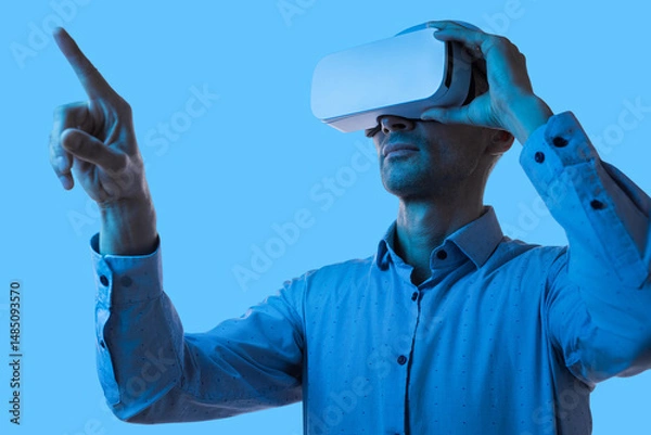 Obraz A man explores immersive virtual reality technology in a dynamic environment, interacting seamlessly with simulated digital interfaces for innovative applications.