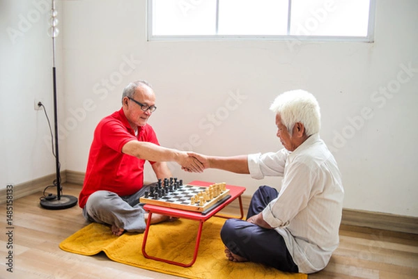 Obraz Portrait Of Two Senior Asian Man Shaking Hands Before Playing Chessboard At Home