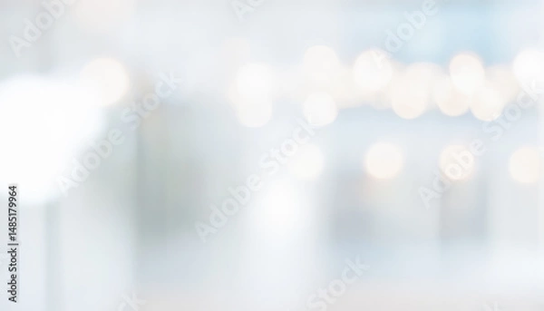 Fototapeta Abstract blurred background with bokeh lights in white and light blue tones.