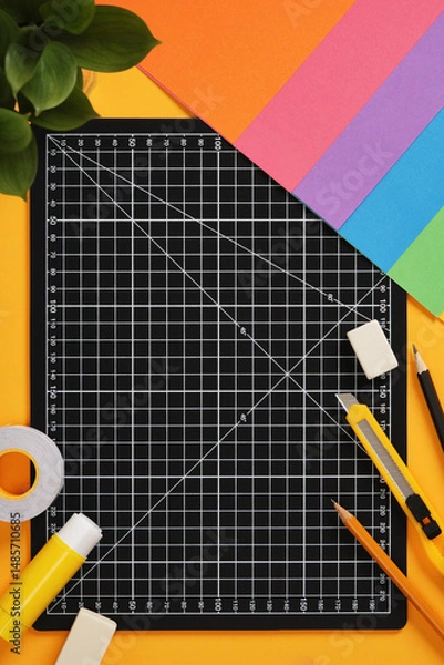 Obraz Top view of the paper crafts work table. Craft knife, pencil, eraser, cutting mat, paper. Place for your text.