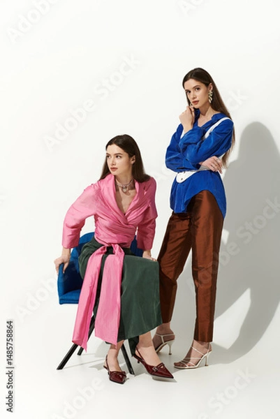 Fototapeta Twin sisters exude charm and style with their coordinated outfits in a chic, minimal environment