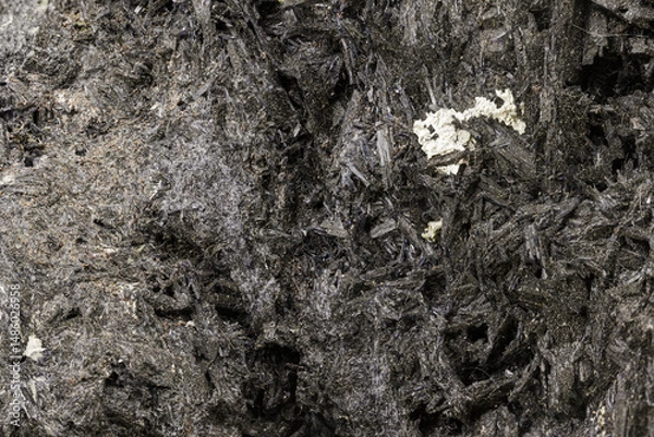 Fototapeta Macro photo of a dark mineral specimen showing fibrous structure and metallic sheen. Useful for geology, earth science, mineralogy, or educational purposes in stock photography