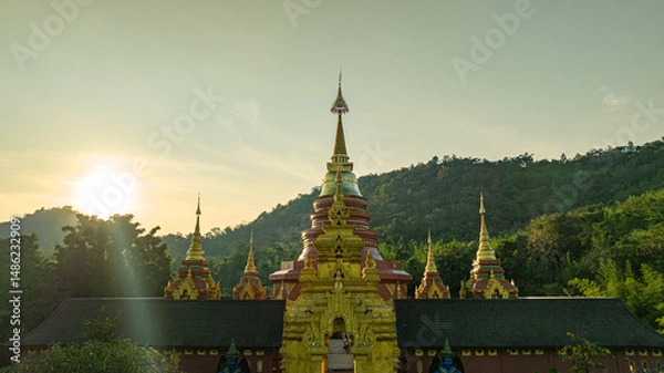 Obraz aerial view of the golden gate with intricate golden architecture at Phra Yai Wat Phra That Doi Phra Chan (Daibutsu) temple..A stunning view of a traditional temple surrounded by lush greenery