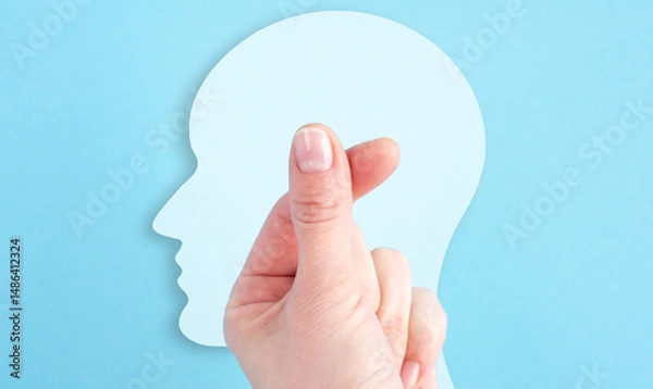 Fototapeta A hand is holding a paper head with a thumb up