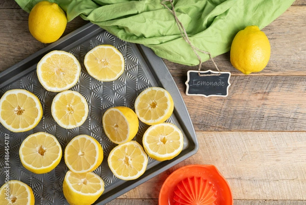 Obraz Lemons cut in halves on a baking sheet, preparing to make lemonade.